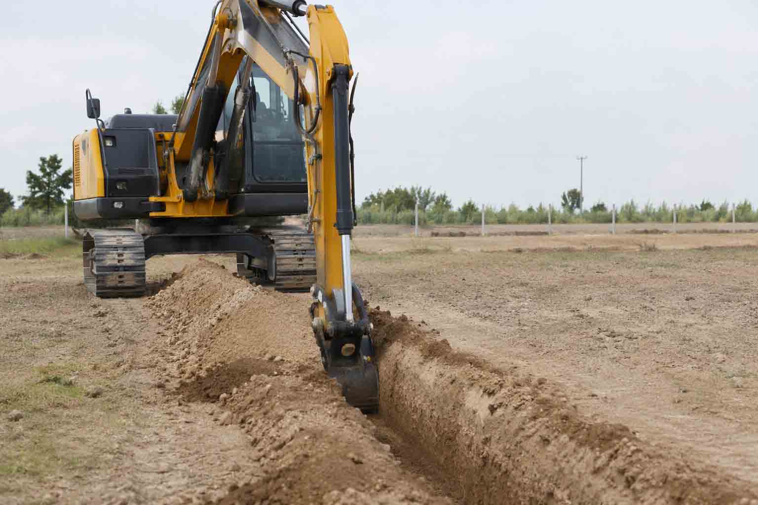 excavator using a narrow trenching bucket for irrigation trenching work