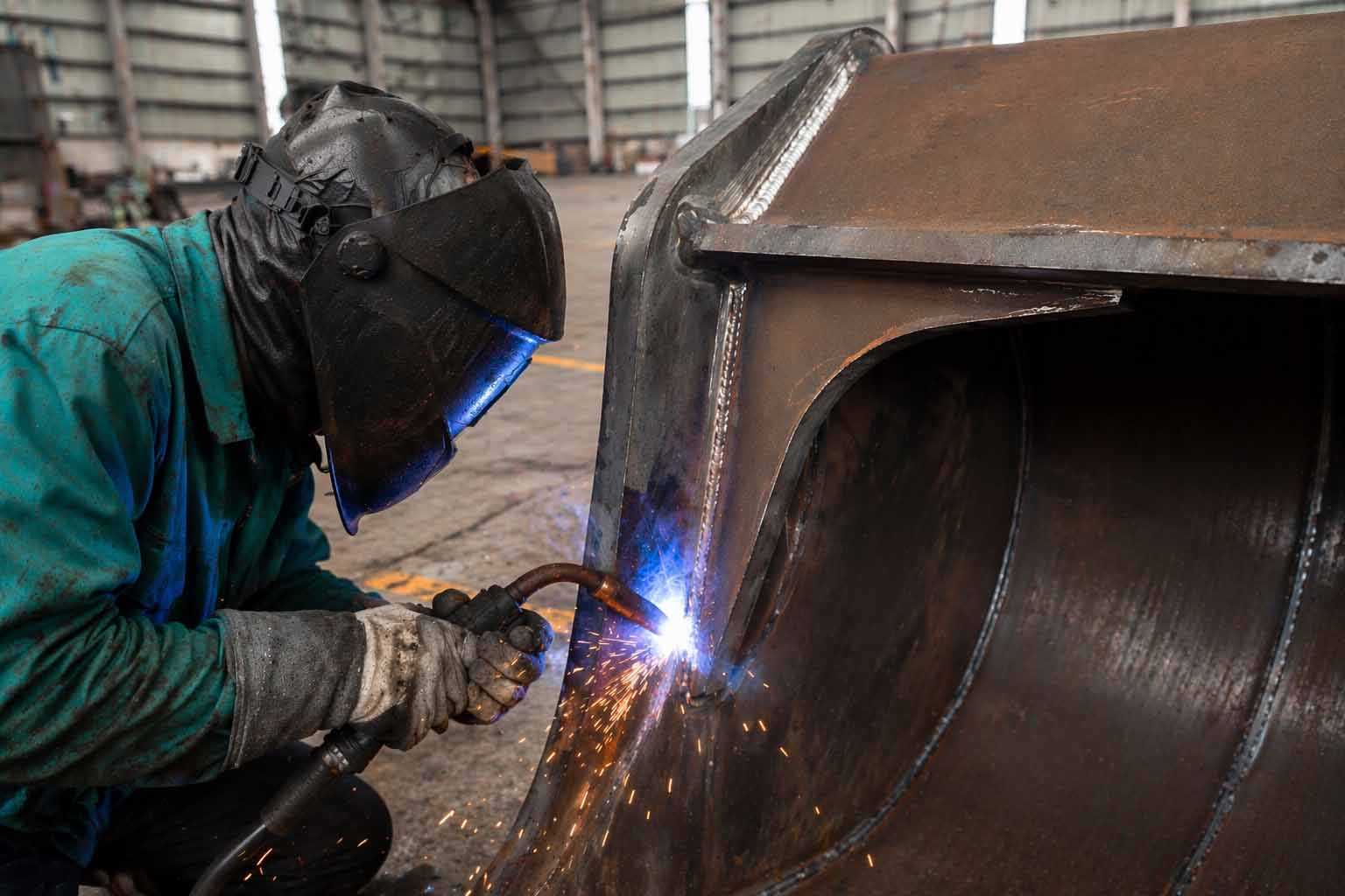Welding process assembling excavator bucket structure.